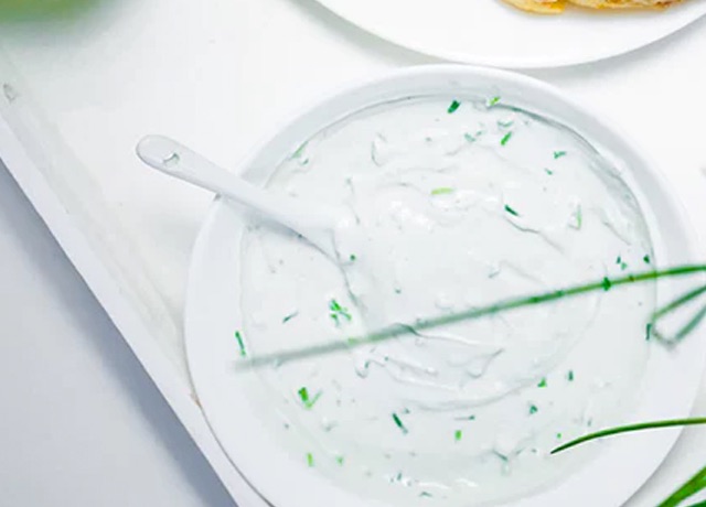 A bowl of cream dressing with chives.